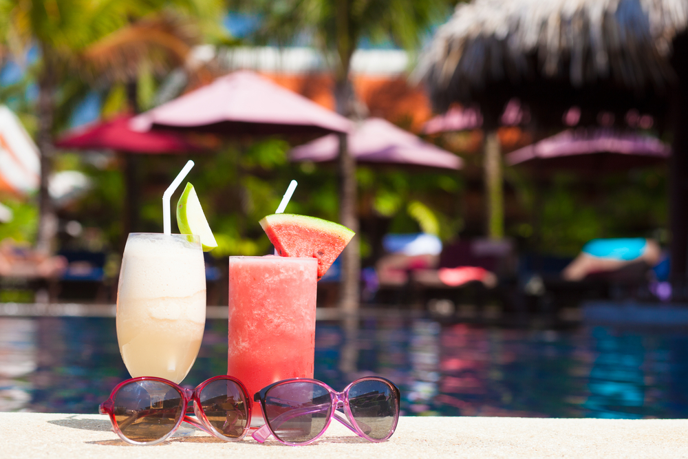 Deux cocktails posés sur le rebord de la piscine.