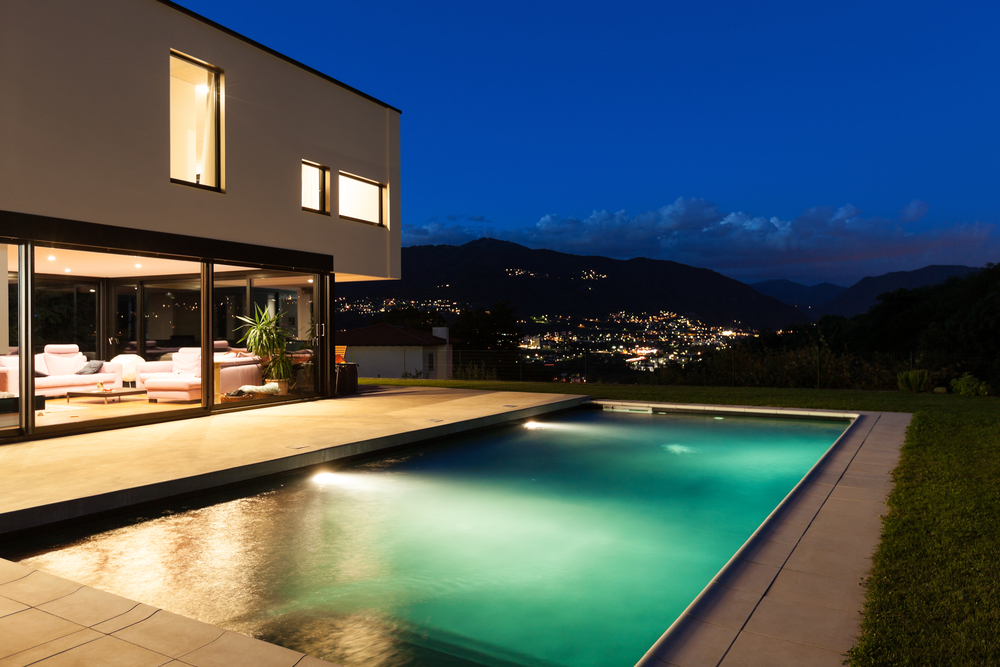 Piscine de nuit, éclairée par des lumières sous-marines.