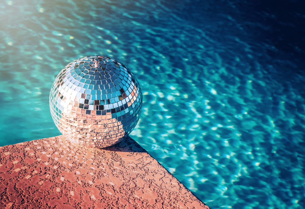 Une boule à facette au bord d'une piscine.